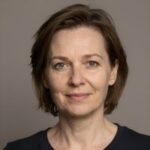 Портрет уверенного российского бизнесмена с дружелюбным взглядом на размытом нейтральном фоне в студии